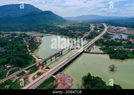 (201116) -- VIENTIANE, Nov. 16, 2020 (Xinhua) -- Aerial photo taken on Oct. 21, 2020 shows the Vientiane-Vangvieng section of the China-Laos expressway (R) next to a bridge of the China-Laos Railway under construction in Vientiane Province, Laos. TO GO WITH 'Feature: Laos eagerly anticipates opening of first expressway' (Yunnan Construction and Investment Holding Group/Handout via Xinhua) Stock Photo