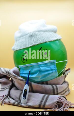 green balloon with hat and mask angry for the cold winter and the covid Stock Photo