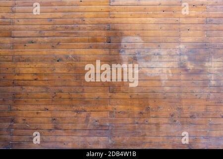 Weathered lumber wall with stain of washed out paint on street, building facade background, texture Stock Photo