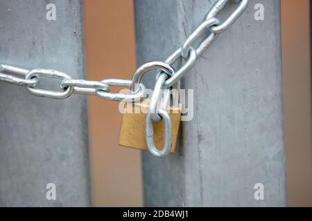 Heavy metal padlock with chain closeup on an entrance gate. Safety, security concept Stock Photo