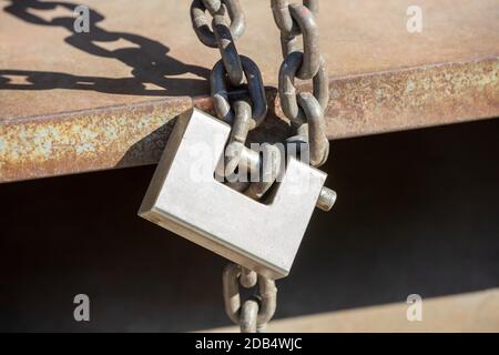 Heavy metal padlock with chain closeup on an entrance gate. Safety, security concept Stock Photo