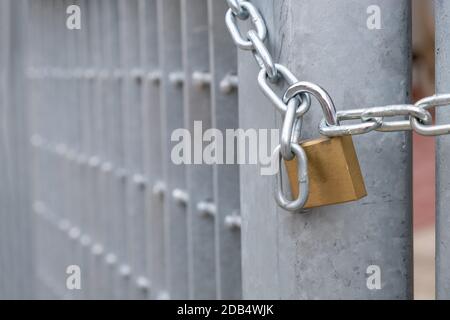 Heavy metal padlock with chain closeup on an entrance gate. Safety, security concept Stock Photo