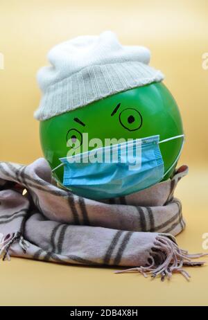 green balloon with hat and mask angry for the cold winter and the covid Stock Photo