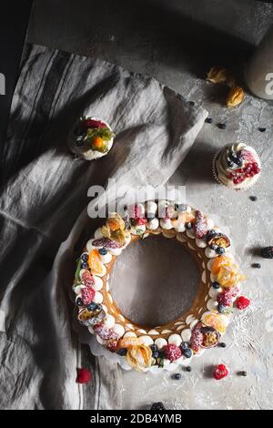 round pie with berries and cupcake on a gray background Stock Photo