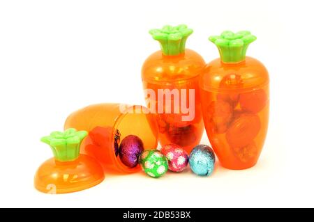 Some festive ways to store Easter candy inside a cute carrot container isolated over white. Stock Photo