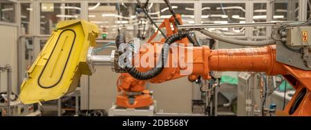 robot arms in the factory performs precise work according to the specified program. Stock Photo