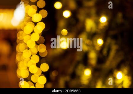Cozy evening in the festive city. Blurred image of trees decorated with light garlands for Christmas and New Year celebration time. Shining trees Stock Photo