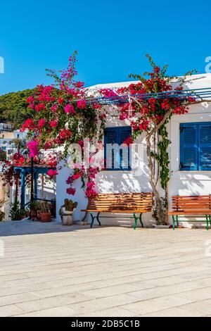 Traditional Cycladitic alley with whitewashed houses and a blooming bougainvillea flowers in lefkes Paros island, Greece Stock Photo