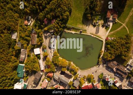 photo taken from above over the lake of cerretano in the resort of cerreto lakes at the foot of the ski slopes illuminated by the sun of an autumn aft Stock Photo