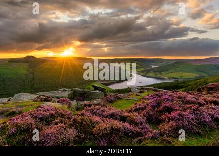 Evening sun bursting through dramatic clouds with epic view of Ladybower Reservoir in the Peak District. Stock Photo