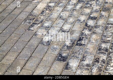 old road made of paving stones for traffic and pedestrians, close-up of a part of the public road , part of the concrete tile is destroyed Stock Photo