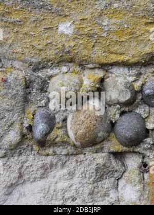 Portrait image of old wall made of concrete and smooth stone pebbles Stock Photo