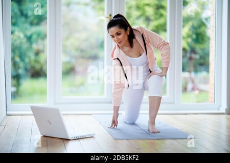 Woman working out to online workout program Stock Photo