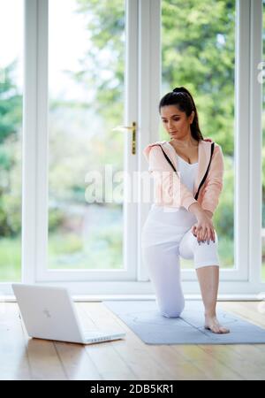 Woman working out to online workout program Stock Photo