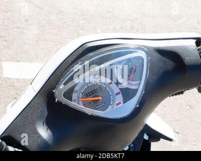 A fragment of a motorcycle steering wheel with a speedometer outdoor. Closeup photo Stock Photo