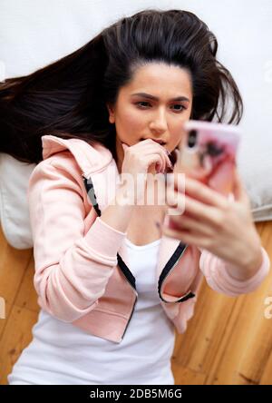 woman looking shocked looking at message Stock Photo