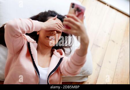 woman looking shocked at text message Stock Photo