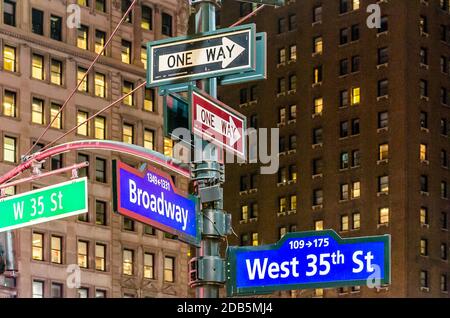 New York City Manhattan Street Signs at Night. Broadway and West 35th St. Buildings in Background. Manhattan, New York City, USA Stock Photo