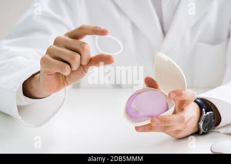 Gynecologist Showing Contraception Ring To Woman And Explaining Contraception And Birth Control Methods Stock Photo