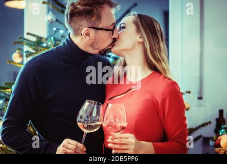 Middle aged couple in romantic pose in front of Christmas tree Stock Photo