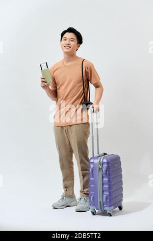 Man traveler with suitcase, passport and ticket on color background ...