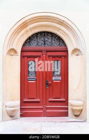 Red-brown double leaf front door in Art Nouveau design with a stone door frame. Stock Photo