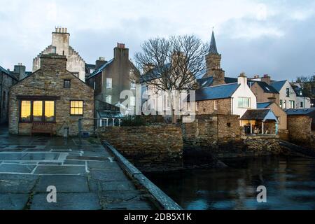 Close waterfront view of traditional vintage houses and tree in scottish town Stromness Stock Photo