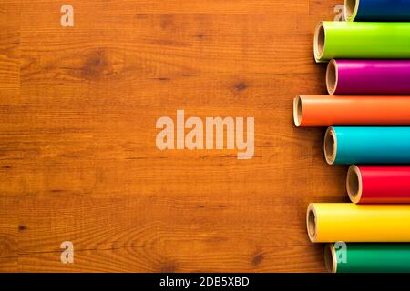 Colored vinyl rolls over wooden background Stock Photo