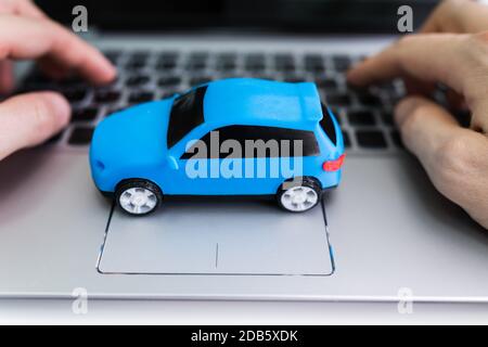 Close-up Of A Small Blue Car On Laptop Keypad Stock Photo