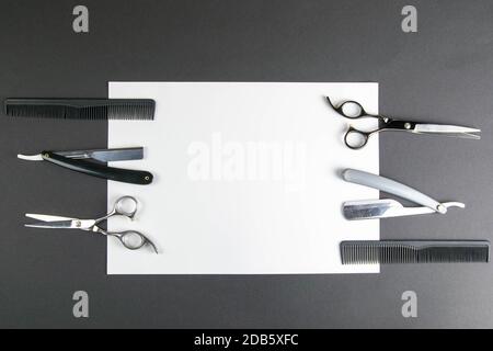Haircut machines, nozzles of different sizes, combs and gels for styling, laid out on a beautiful black white striped background which stands on a gra Stock Photo