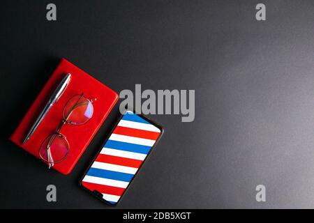 Photo of Smart phone, note book, eye glasses pen on a black background. Stock Photo