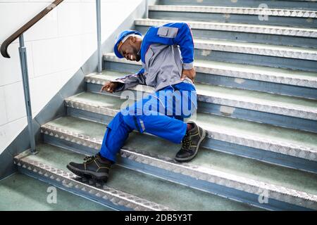 Worker Man Lying On Staircase After Slip And Fall Accident Stock Photo