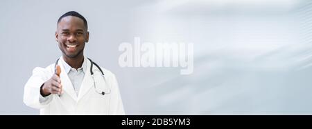 Portrait Of Happy Confident Doctor Offering Handshake In Hospital Corridor Stock Photo