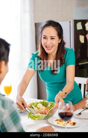 Woman serving salad she made Stock Photo