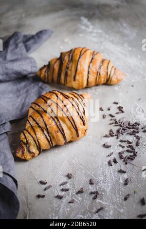 two fresh croissants on wooden board and cloth napkin Stock Photo