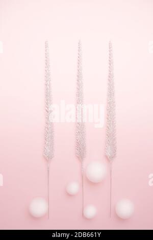 Christmas decorations shiny Christmas trees and white balls on pastel pink background. New Year holiday winter concept. Flat lay, top view, copy space. Vertical. Stock Photo