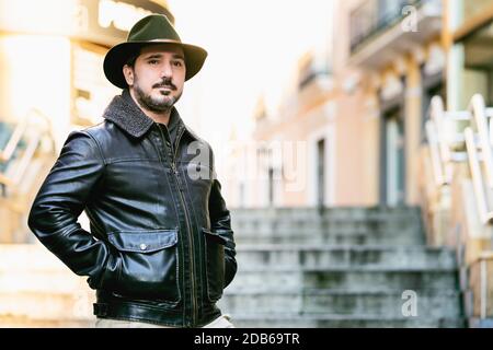 mature man with hat and jacket standing on stairs with copy space for text Stock Photo