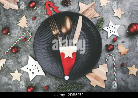 Christmas concept background.Vintage old cutlery with Santa claus hat served on plate for Christmas Dinner with Christmas decoration Stock Photo