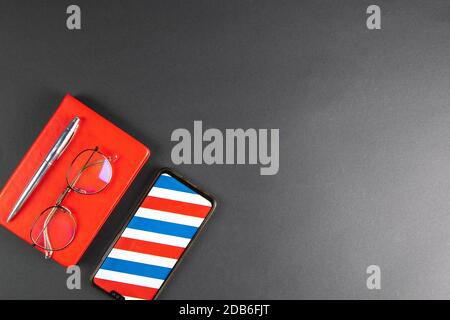 Photo of Smart phone, note book, eye glasses pen on a black background. Stock Photo