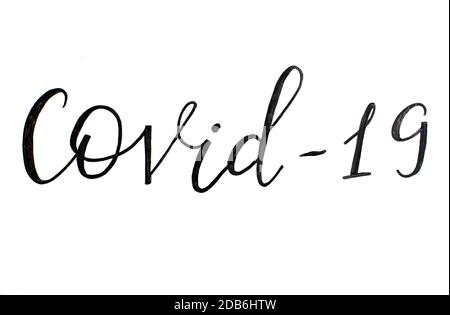 Black handwritten inscription COVID-19 on a white  background Stock Photo