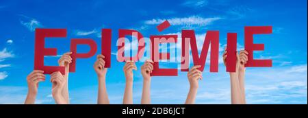 People Hands Holding Colorful French Word Epidemie Means Epidemic. Blue Sky As Background Stock Photo