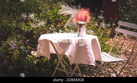 Table and Chair set decorate on A Garden for wedding Party or Celebration Outside. Stock Photo