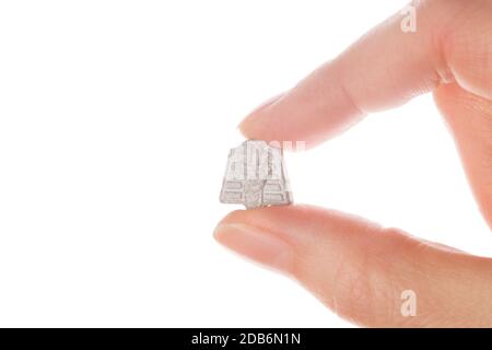 Ecstasy pill in female hand isolated on white background. MDMA therapeutical use. Stock Photo