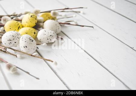 Easter decorations. Willow twigs and decorative Eggs on white wooden background Stock Photo