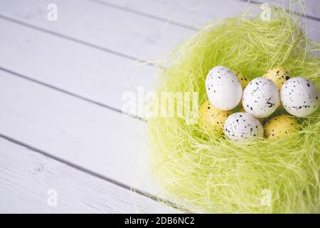 Easter decorations. Eggs in nests on white wooden background Stock Photo