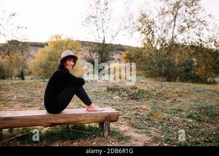 Woman practicing yoga and stretching on the park bench Stock Photo