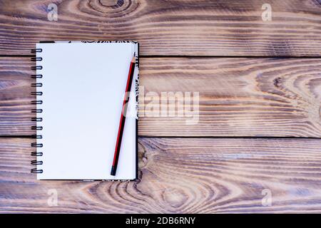 Blank notepad and pencil on wooden background Stock Photo