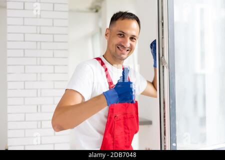 master with a screwdriver sets fittings on the window Stock Photo