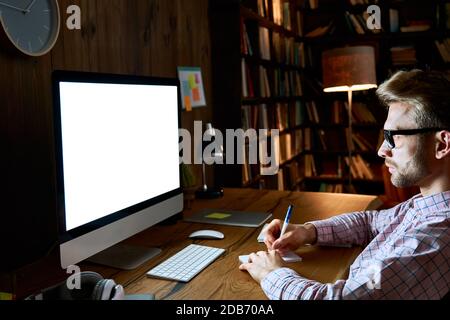 Serious business man using computer looking at mockup white screen monitor. Stock Photo
