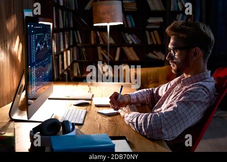 Business man trader looking at pc analyzing financial chart trading data. Stock Photo